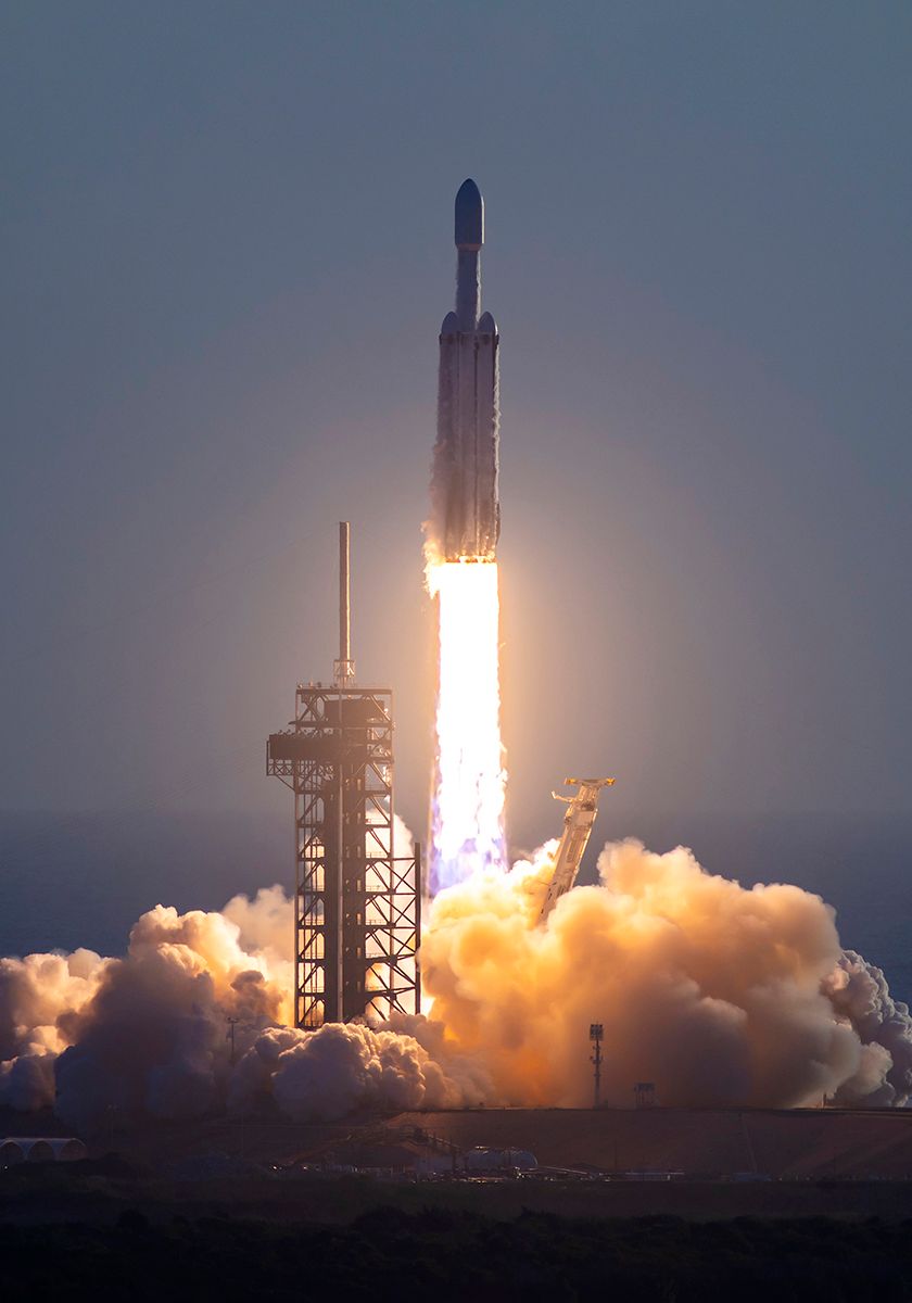 Foguete Falcon Heavy decolando ao entardecer com nuvem de fumaça na base