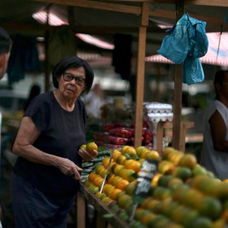 Consumidora escolhe alimentos em feira livre